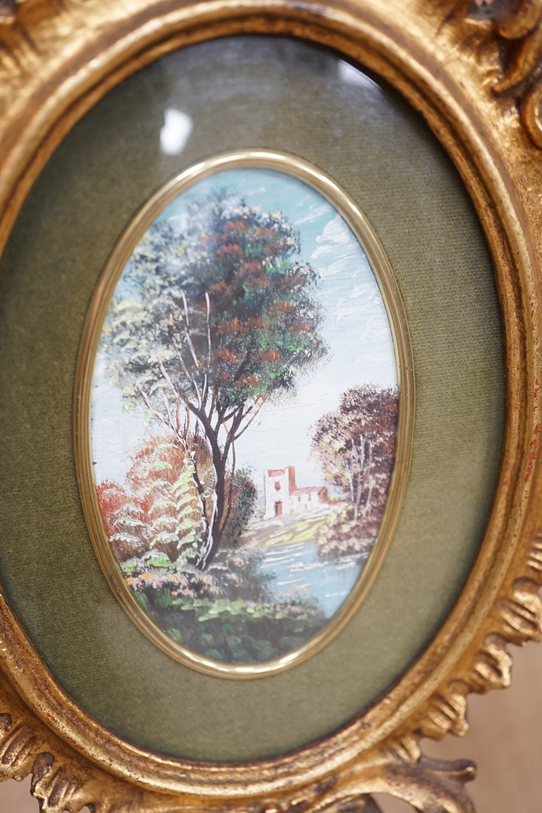 A pair of miniature Italianate landscapes, with pierced, carved oval giltwood frames. 29cm high overall